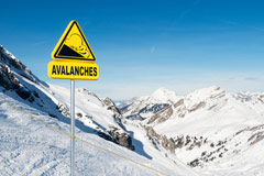Avalanche sign on top of mountain warning snowmobilers