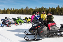 Snowmobilers on trail looking at map
