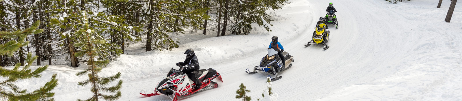 Snowmobilers riding trails