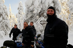Group of snowmobilers in snow-laden trails